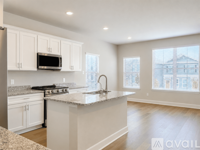 A kitchen with white cabinets and a granite countertop.