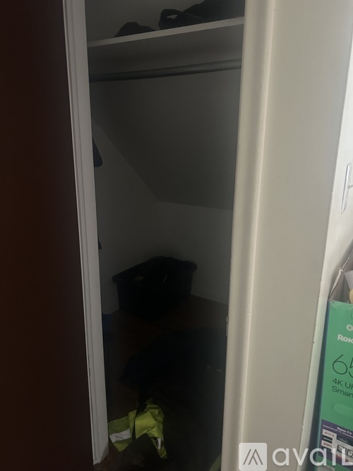 A small closet with a white door and a sign on the door.