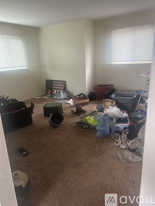 A room with a lot of clutter and a picture frame on the wall.
