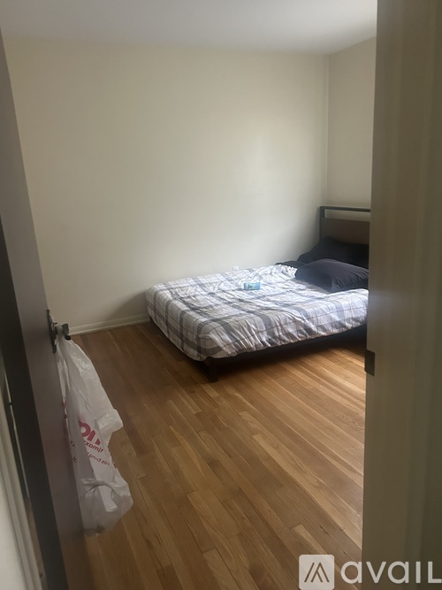 A bedroom with a bed and a bag on the floor.