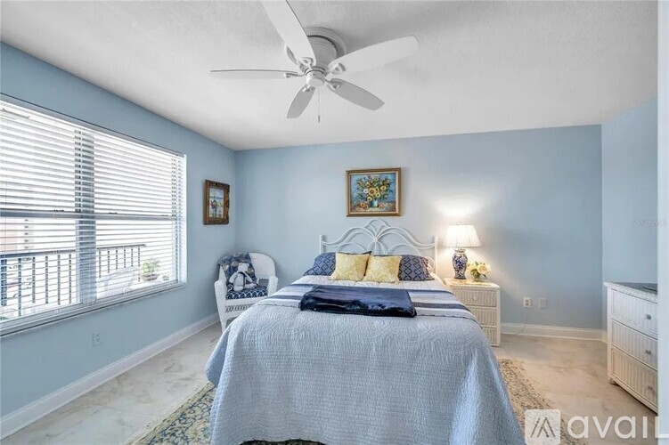 A bedroom with a bed, a chair, and a ceiling fan.