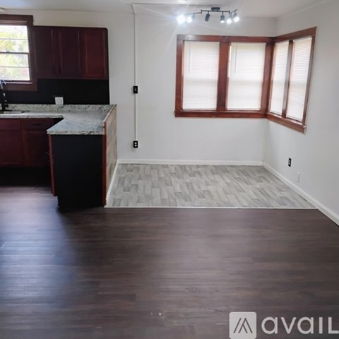A kitchen with dark wood cabinets and a marble countertop.