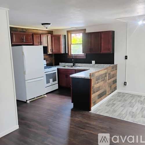 A kitchen with wooden cabinets and a white refrigerator.
