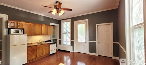 A kitchen with wooden cabinets and a white refrigerator.