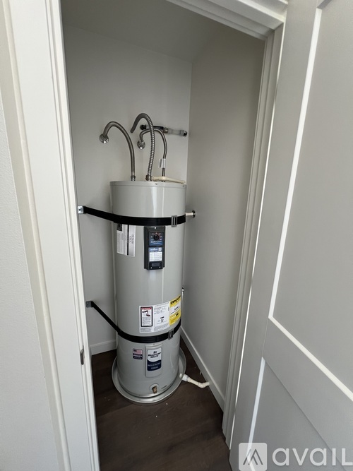 A water heater is installed in a narrow space between two walls.