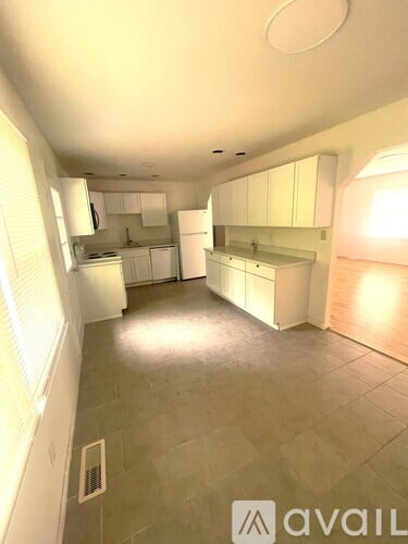 A kitchen with white cabinets and a tiled floor.