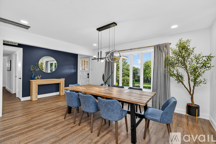 A dining room with a wooden table and blue chairs.