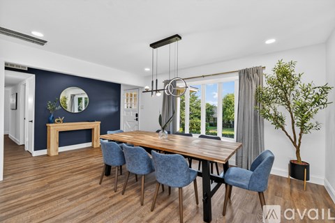 A dining room with a wooden table and blue chairs.