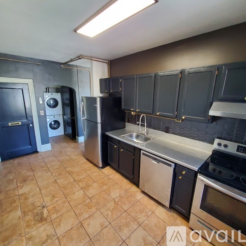 A kitchen with dark cabinets and a tile floor.