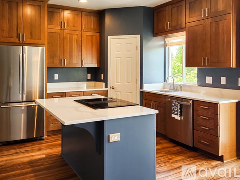 A kitchen with wooden cabinets and a white island.