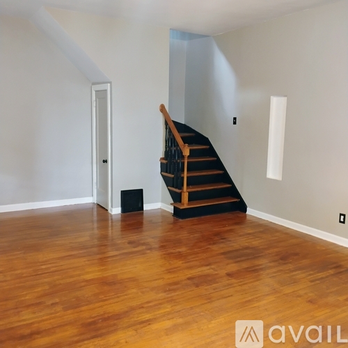 A wooden staircase in a room with white walls.