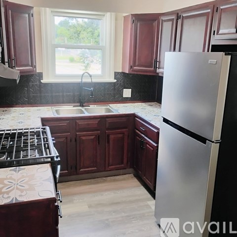A kitchen with a refrigerator, sink, and stove.