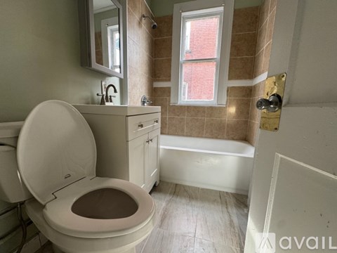 A bathroom with a toilet, sink, and tub.