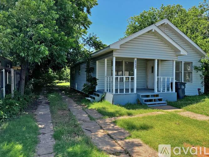 A house with a porch and a driveway leading to the front door.