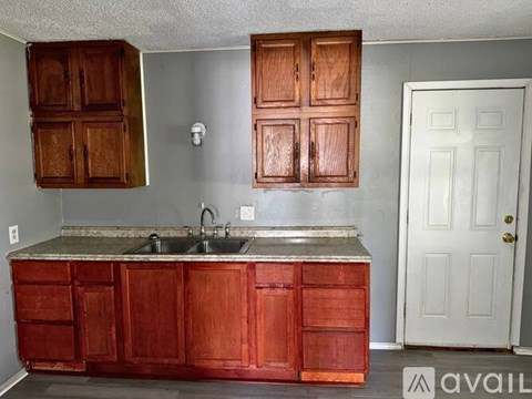 A kitchen with wooden cabinets and a white door.