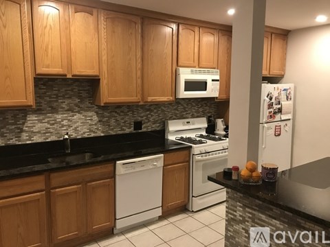 A kitchen with wooden cabinets and a white dishwasher.