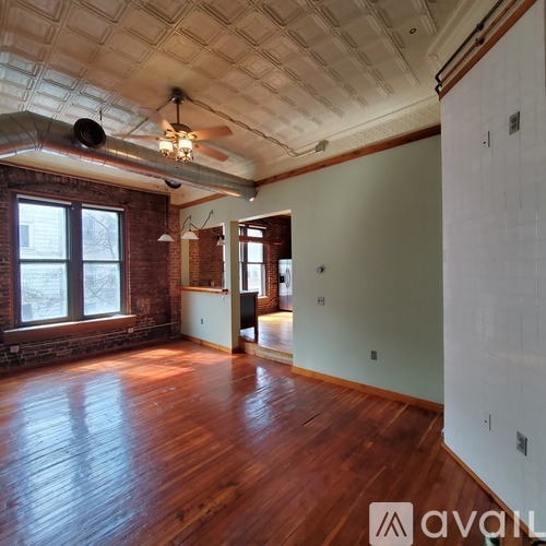 A room with wooden floors and a ceiling fan.