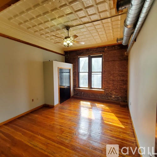 A room with wooden floors and a ceiling fan.