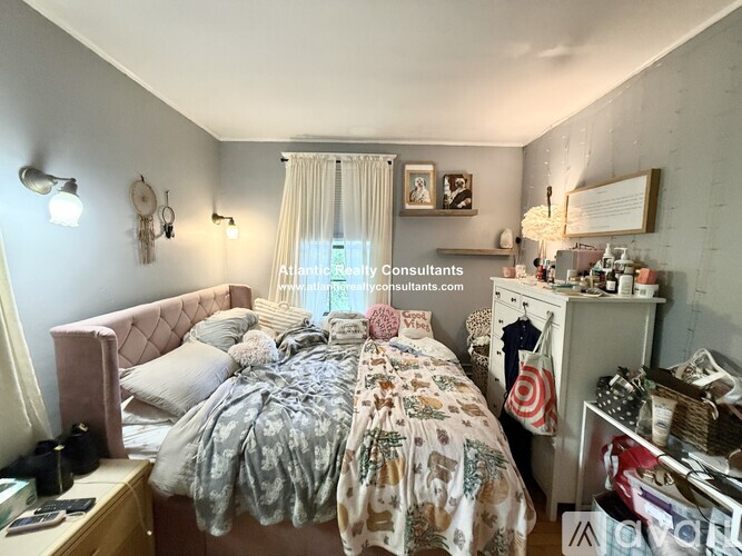 A bedroom with a bed, nightstand, and a dresser with a mirror.