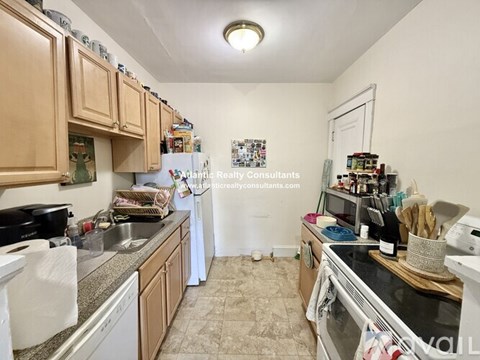 A kitchen with wooden cabinets and a refrigerator.