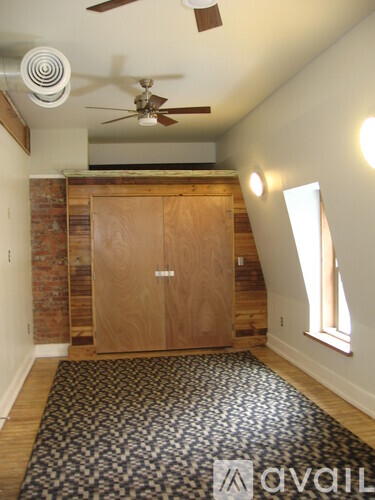 A room with a ceiling fan and a wooden door.