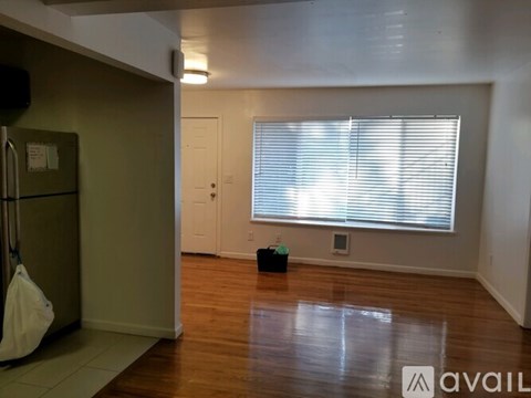 A room with wooden floors and a window with blinds.