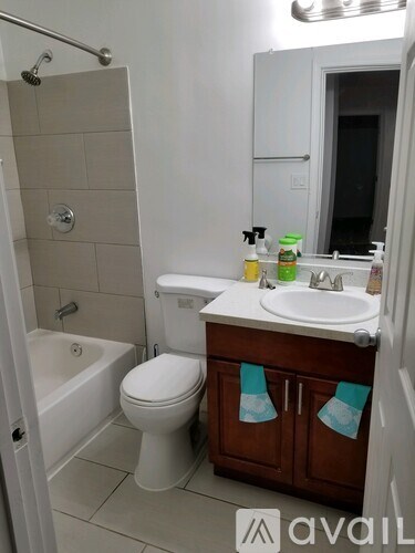A bathroom with a white toilet, sink, and bathtub.