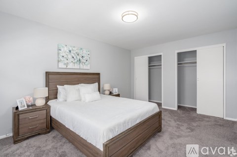 A bedroom with a large bed and a painting on the wall.