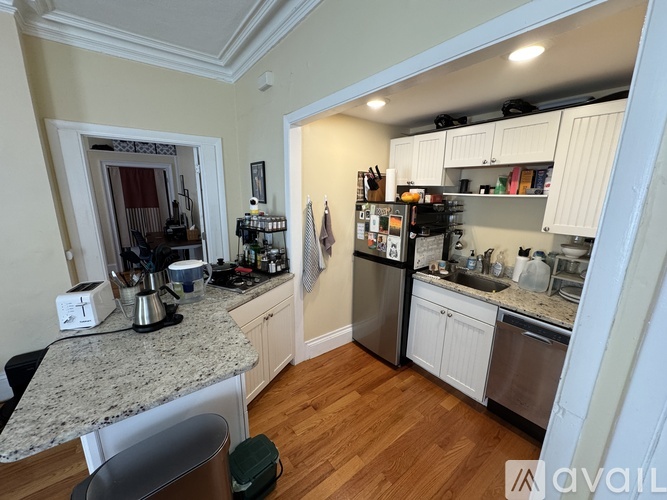 A kitchen with white cabinets and a granite countertop.
