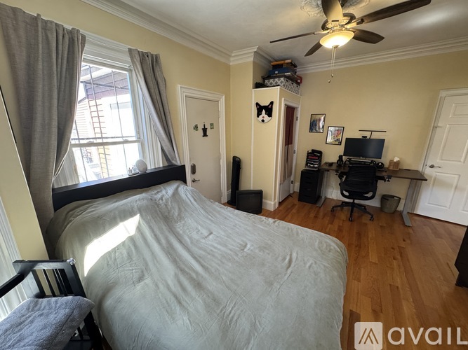 A bedroom with a large bed and a ceiling fan.