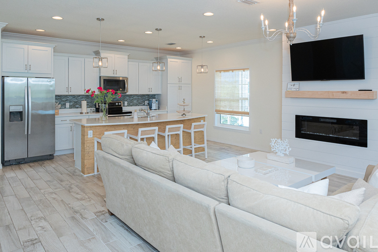 A modern kitchen with a refrigerator, sink, and a dining table with chairs.