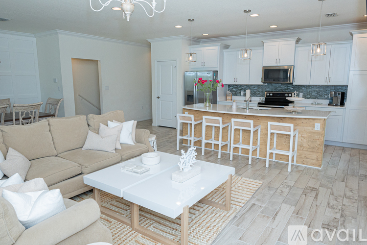 A living room with a beige couch and a white coffee table.