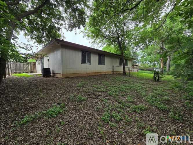 A small house surrounded by trees and grass.