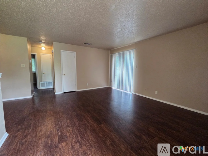 A room with wooden floors and a window with blinds.