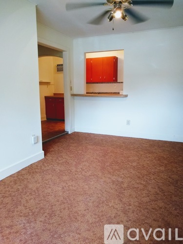 A room with a ceiling fan and a red cabinet.