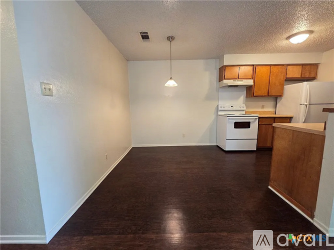 A kitchen with white appliances and wooden cabinets.