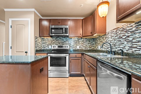 A kitchen with wooden cabinets and a stone backsplash.