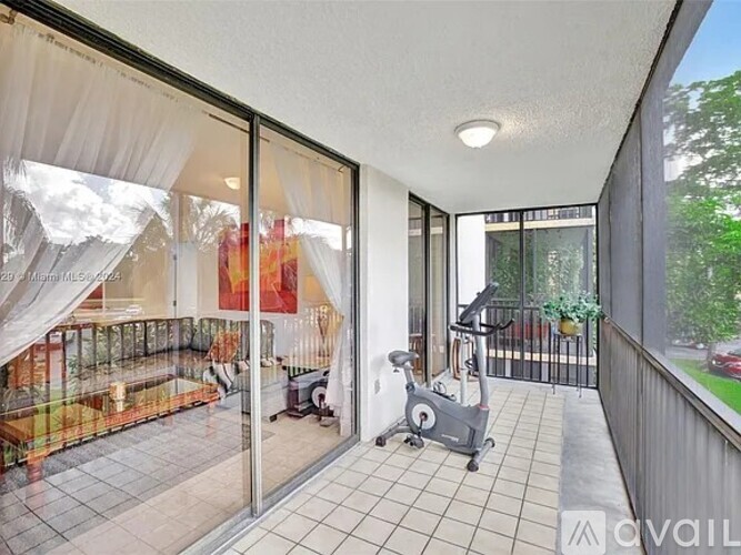 A balcony with a treadmill and a view of the backyard.