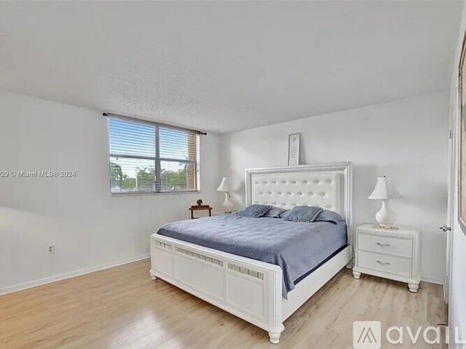 A bedroom with a large bed and two nightstands.