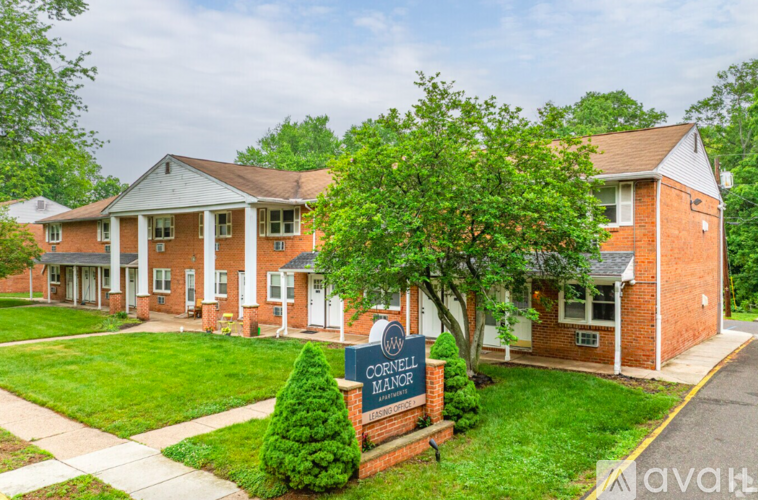 A brick building with a sign that says Cornell Manor.