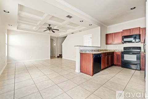 A kitchen with white cabinets and black appliances.