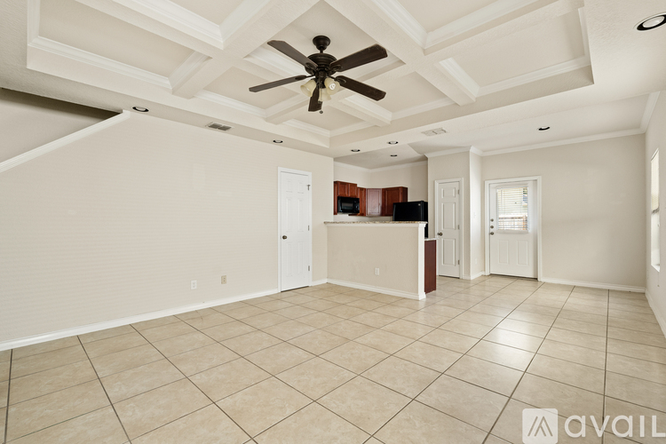 A spacious room with a ceiling fan and tiled flooring.