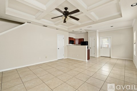A spacious room with a ceiling fan and tiled flooring.
