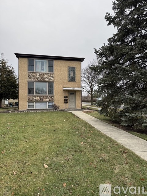 A house with a stone wall on the side is for sale.