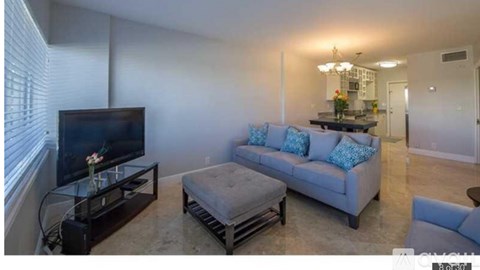 A living room with a grey couch and a flat screen TV.