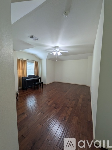 A room with wooden floors and a piano.
