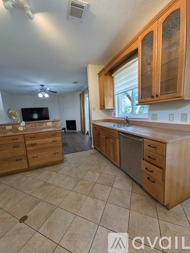 A kitchen with wooden cabinets and a tile floor.