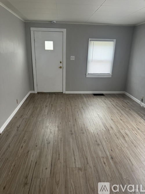 A room with a wooden floor and a white door.