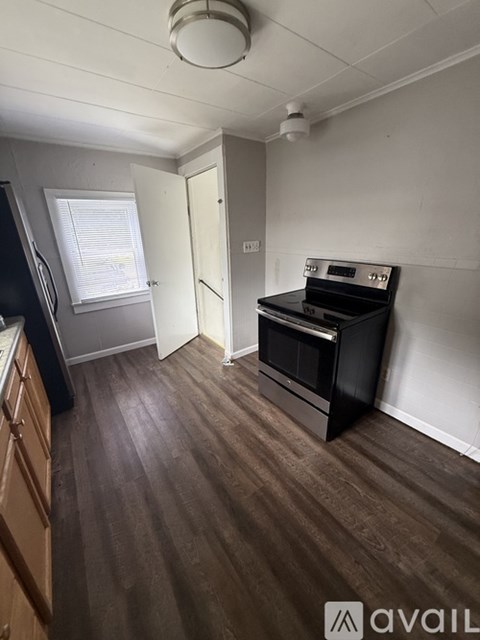 A kitchen with a black oven and wooden floors.