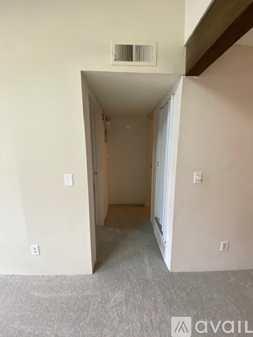 A room with a carpeted floor and a white ceiling with a vent.